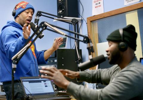 Shay Glorious Martin talks to Nick Muhammad in radio station studio.